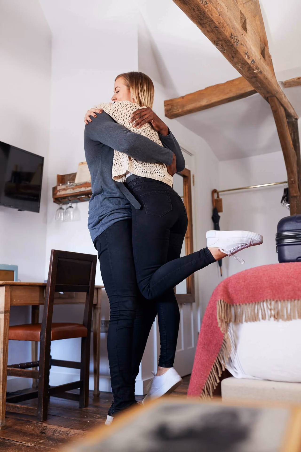 Couple Spending Romantic Weekend Away Hugging In Hotel Room